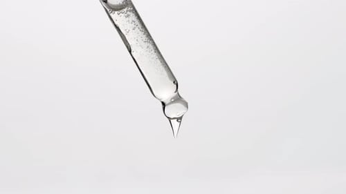 Clear Liquid Dripping From the Tip of a Pipette