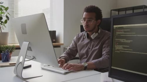 Biracial Programmer Working on Desktop Computer in Office