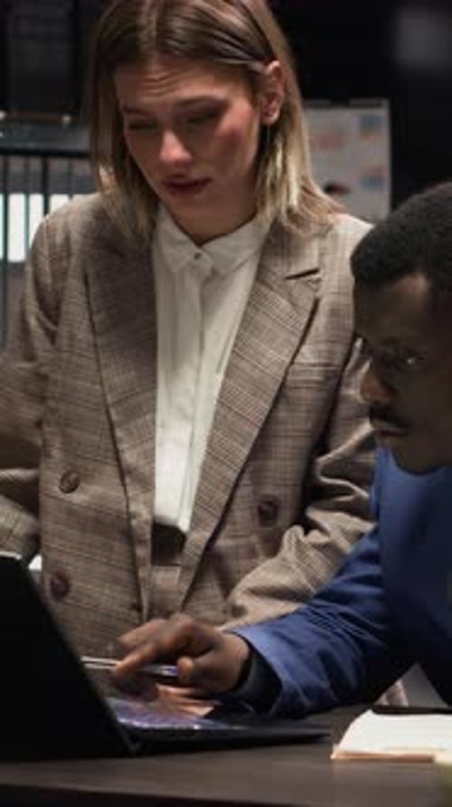 Professionals Collaborating on a Laptop in Modern Office