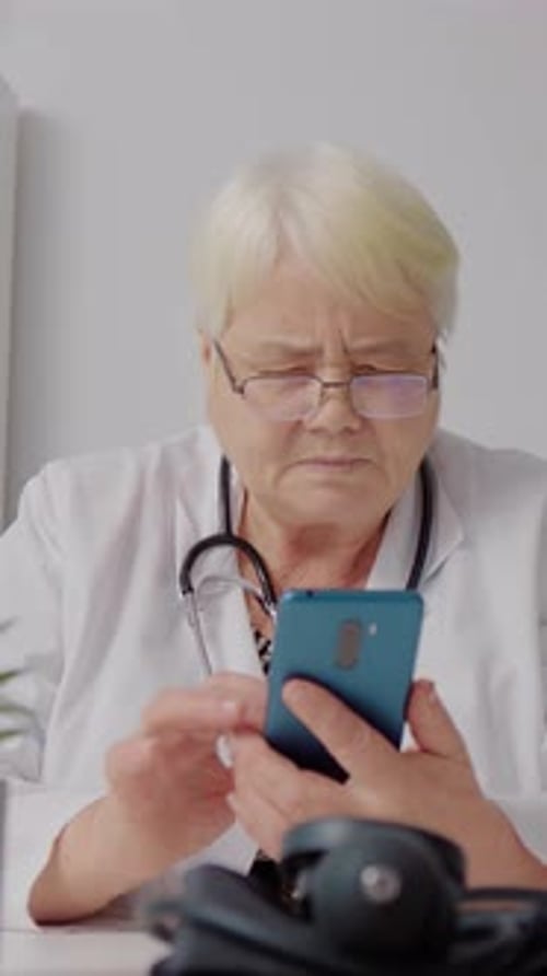 Vertical Screen Woman doctor using technology during break time.