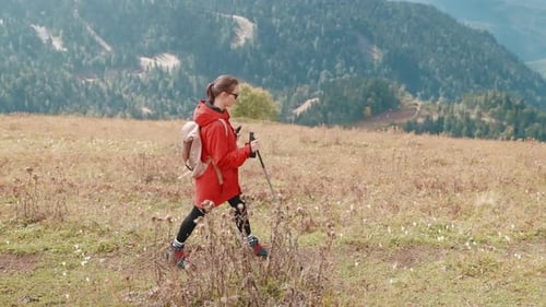 Hiker Woman Walking on Mountain Slope Hiking Holding Sticks in Hands