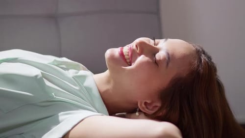 Smiling Woman Lying on Sofa Indoors