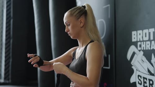 Female Boxer Wrapping Hands Before Training