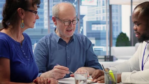 Mature Man Signing Document in Modern Office Setting