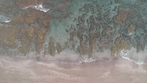 Aerial view with drone over a southern Spanish beach in Marbella, Andalusia, Spain, calm waves on cr