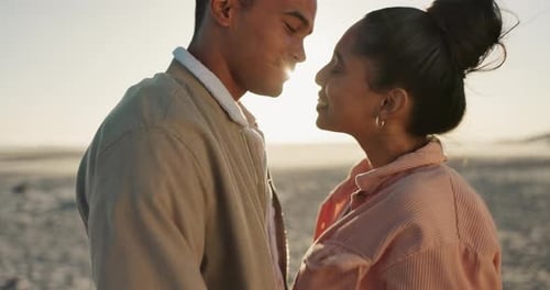 Couple, love and kiss on beach for happy date, romance and celebration of valentines day in sunset