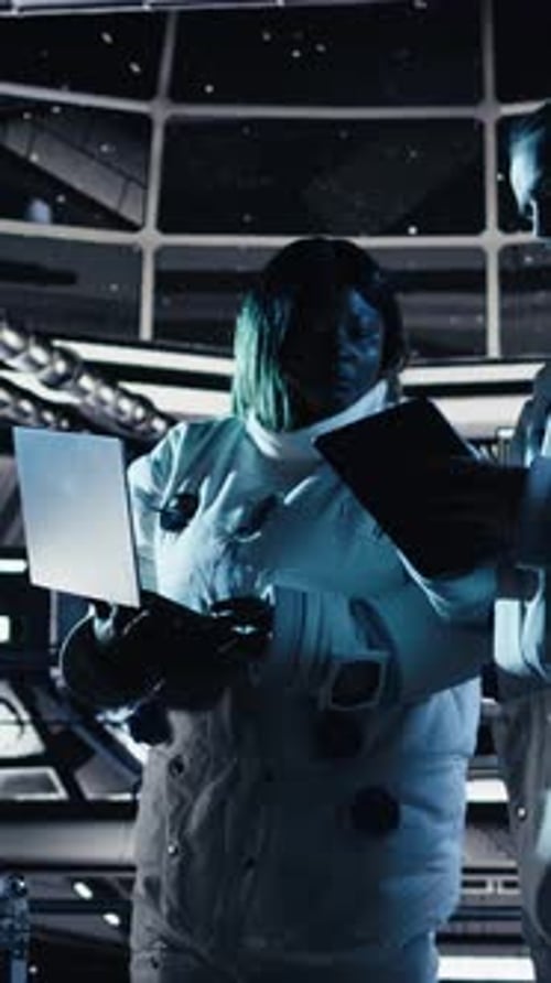 Vertical Video Astronaut Reviewing Onboard Analytics on Laptop Before Stepping Out of Station