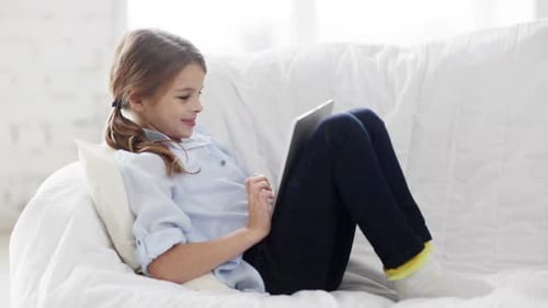Education, Free Time, Technology And Internet Concept - Little Student Girl With Tablet Pc At Home