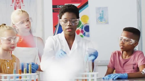 Diverse female teacher and happy schoolchildren having science class in school lab