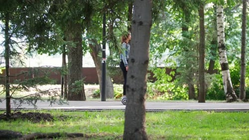 Girl Drives Past the Camera on a Gyro in the