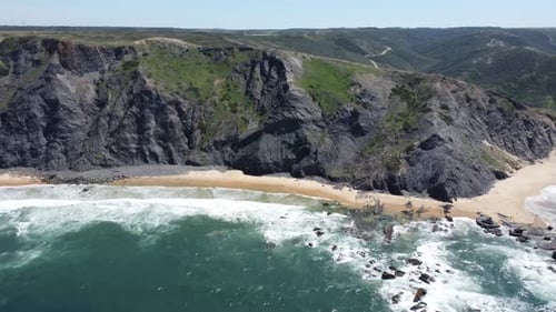 drone shot of a nice sandy beach with some rocks