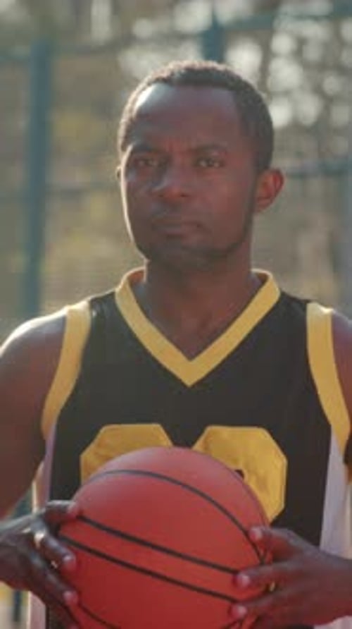 Spielvorbereitung unter hellem Licht: Engagierter Spieler bereitet sich mental auf den bevorstehenden Basketball vor