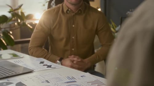 Business People Shaking Hands Over Data in Office