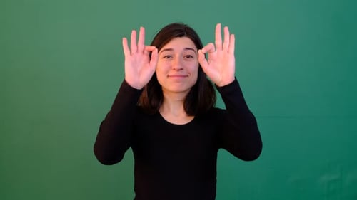 Woman Gives Okay Hand Sign on Green Screen