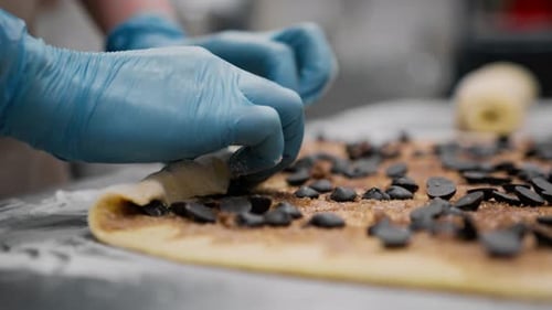 Hands Add Chocolate Chips to Pastry Dough