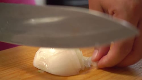 Close-up of Person Slicing Onion with Knife