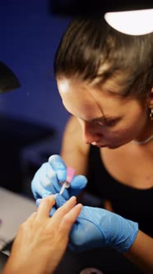 Woman Applying Nail Polish at Manicure Table
