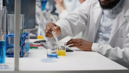 Scientist Using Pipette in Lab with Blue Liquid