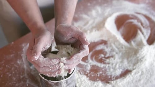 Baker Prepares Dough with Flour on Table