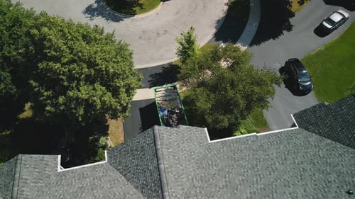 Drone Wide Footage of Dumpster Full of Garbage From an Home