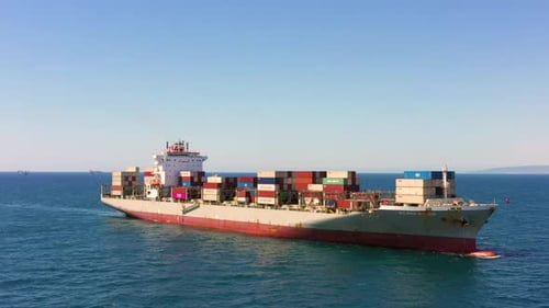 Large loaded Container ship cruising across the open Sea, Aerial view