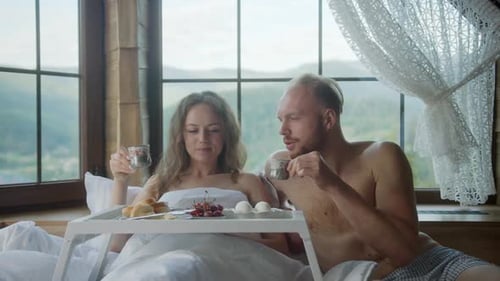 Pareja amorosa desayuna disfrutando de un delicioso café en la cama