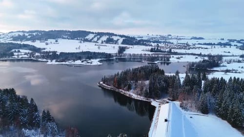 Winter season in the countryside. Rocky slopes covered with snow and pine trees.