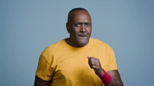 Closeup African American Man Strong Sportsman Boxer Jogger Training in Blue Background Studio