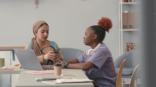 Colegas multiétnicas conversando no local de trabalho