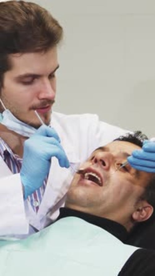Dentist Examining Patient in Dental Clinic