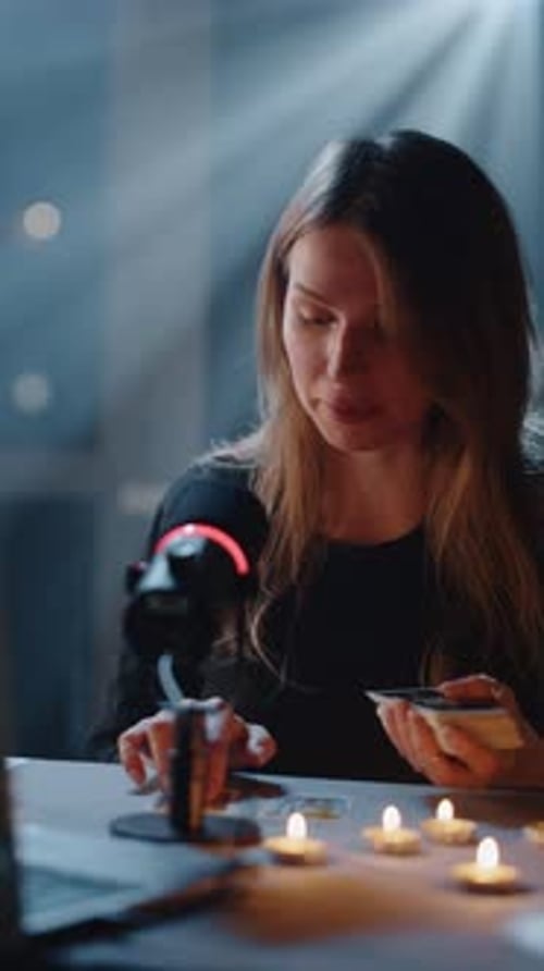 Woman Reads Tarot Cards at Table with Candles