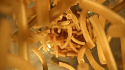 Dry Elbow Macaroni Pasta Falling Into a Bowl