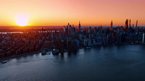 Bright setting sun sending last rays on the scenery of New York. Golden hour in metropolis from top.