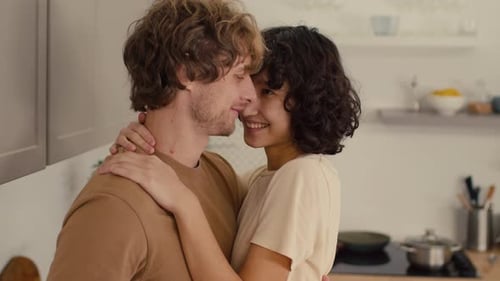Loving Couple Embracing and Kissing in Kitchen