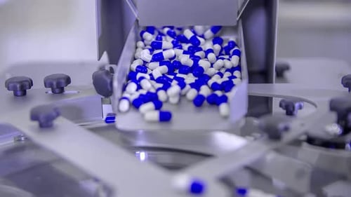 Pills for Coronavirus treatment falling into a spinning plate during its mass production