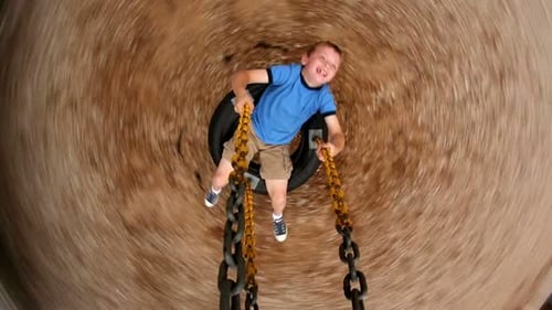 Boy Spinning Tire Swing At School Playground