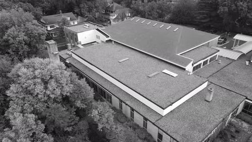 Black and white look of an overgrown area ta church.