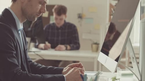Businessman Typing on Wireless Keyboard in Office