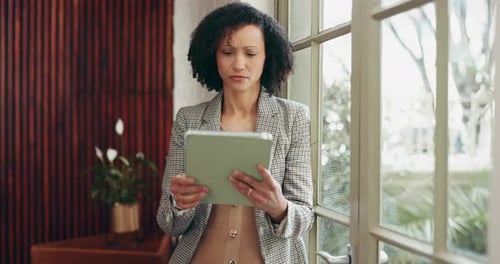 Professional Woman Uses Tablet Indoors By Window