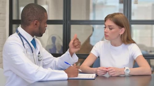 African Male Doctor Talking with Female Patient