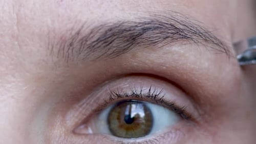 woman eye close up remove pluck eyebrows hair or massaging under with derma roller