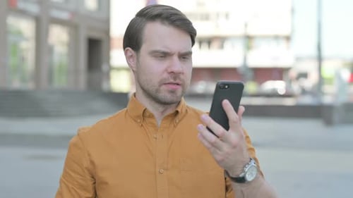 Frustrated Man Using Smartphone in the City