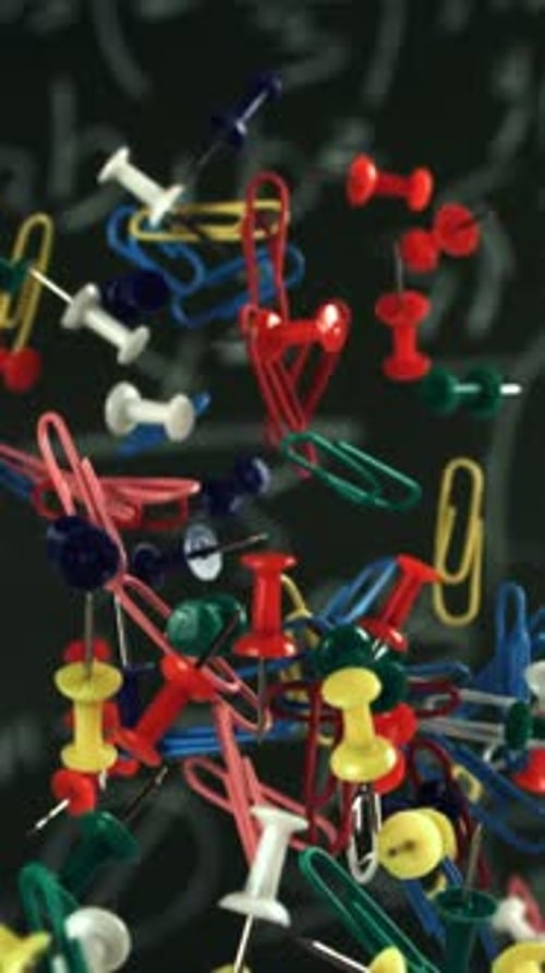 Different School Objects Fly and Fall Against the Background of the Blackboard Filmed on a Highspeed