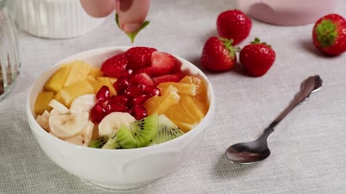 Preparing a Refreshing Fruit Bowl with Mint