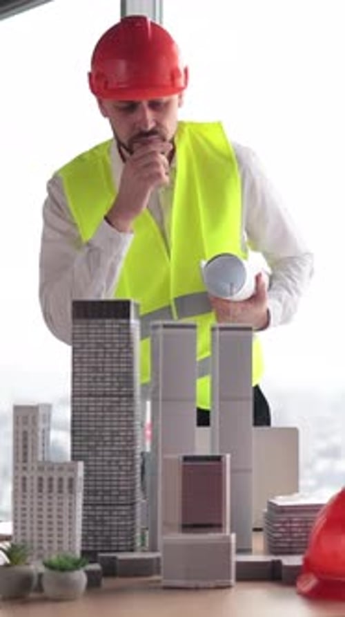 Architect Inspecting Building Models