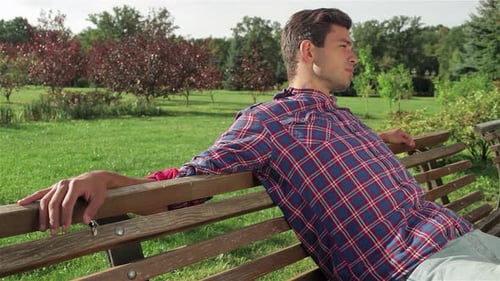 Relaxed Male Resting His Hands on a Park Bench