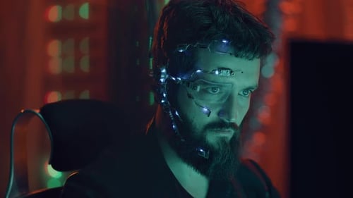 Brunette Guy avec casque et micro fonctionne sur ordinateur, lumière néon de style cyberpunk