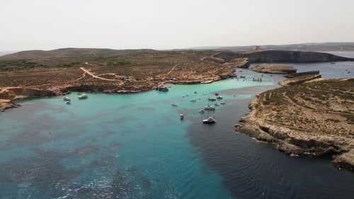 Aerial view of Blue Lagoon with boats in turquoise water, Malta.
