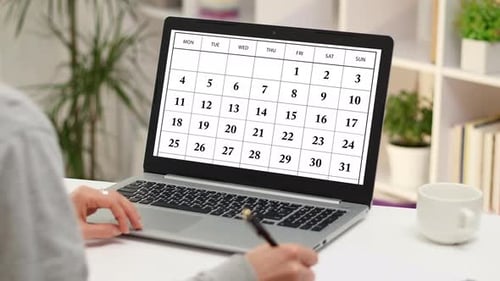 Woman Using Calendar on Laptop for Planning
