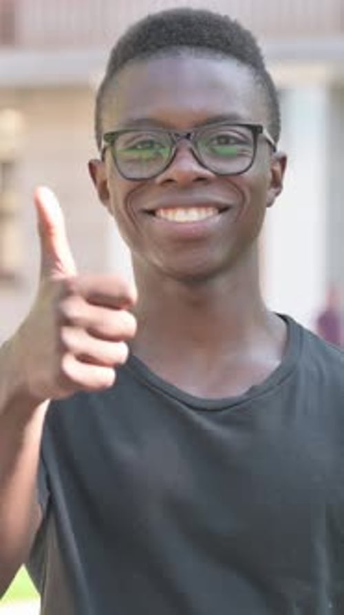 Smiling Young Man Gives Thumbs Up Approval